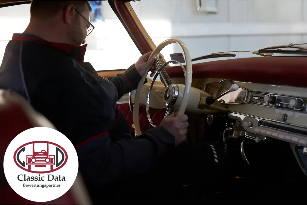 Hero-Bild: Freudiger Mann am Steuer eines stilvollen Oldtimers